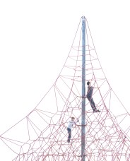 Two children climb a tall red rope structure against a clear sky.